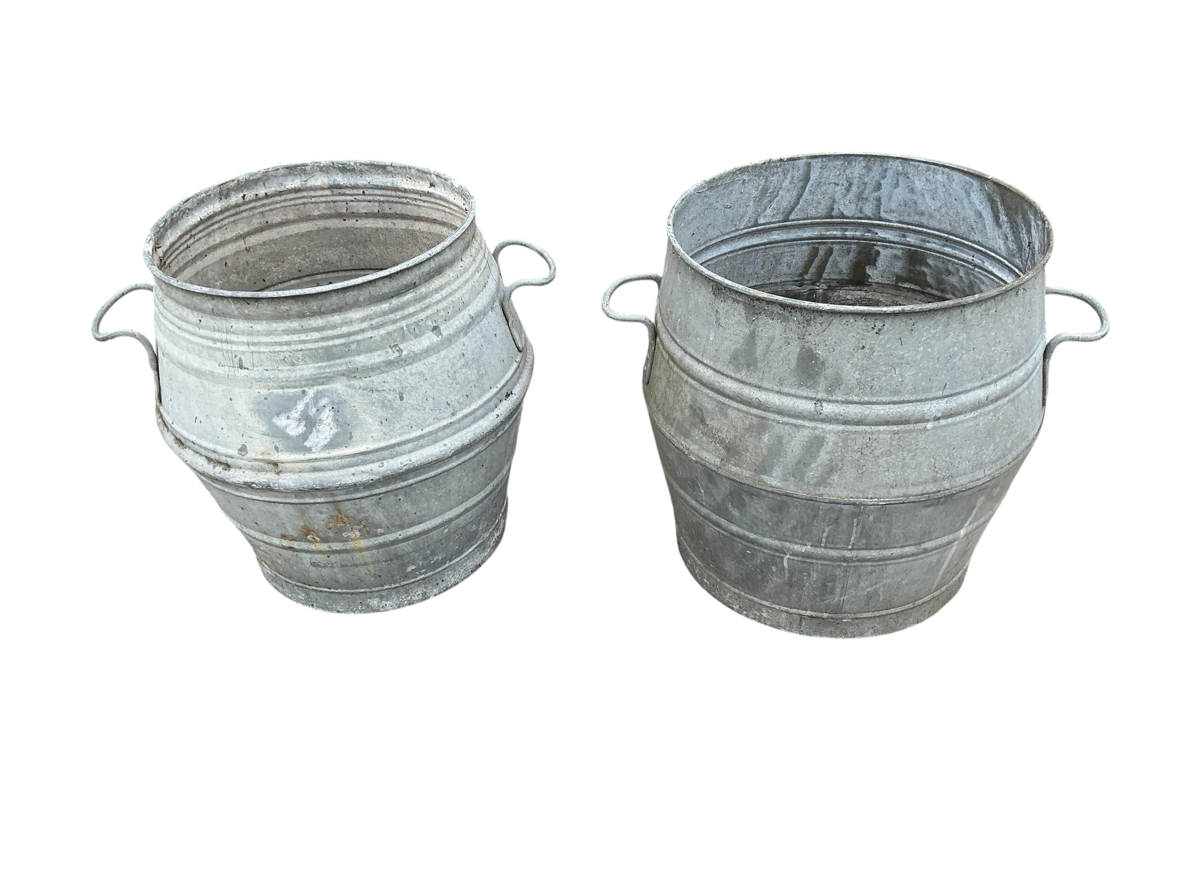 A near pair of circular galvanised metal barrels, diameter 46cm, height 52cm
